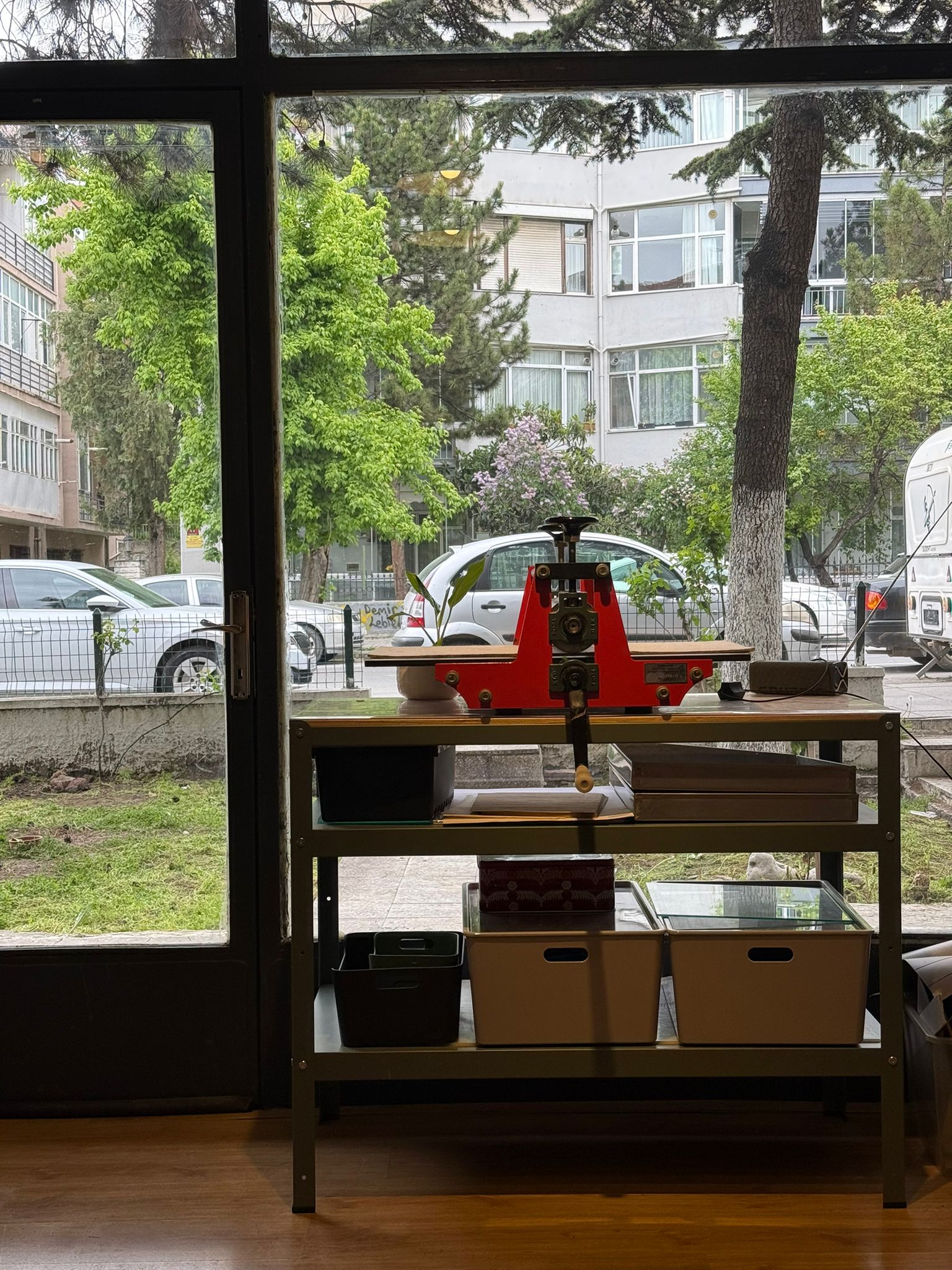 Atölye penceresinden — baskı presi ve sokak